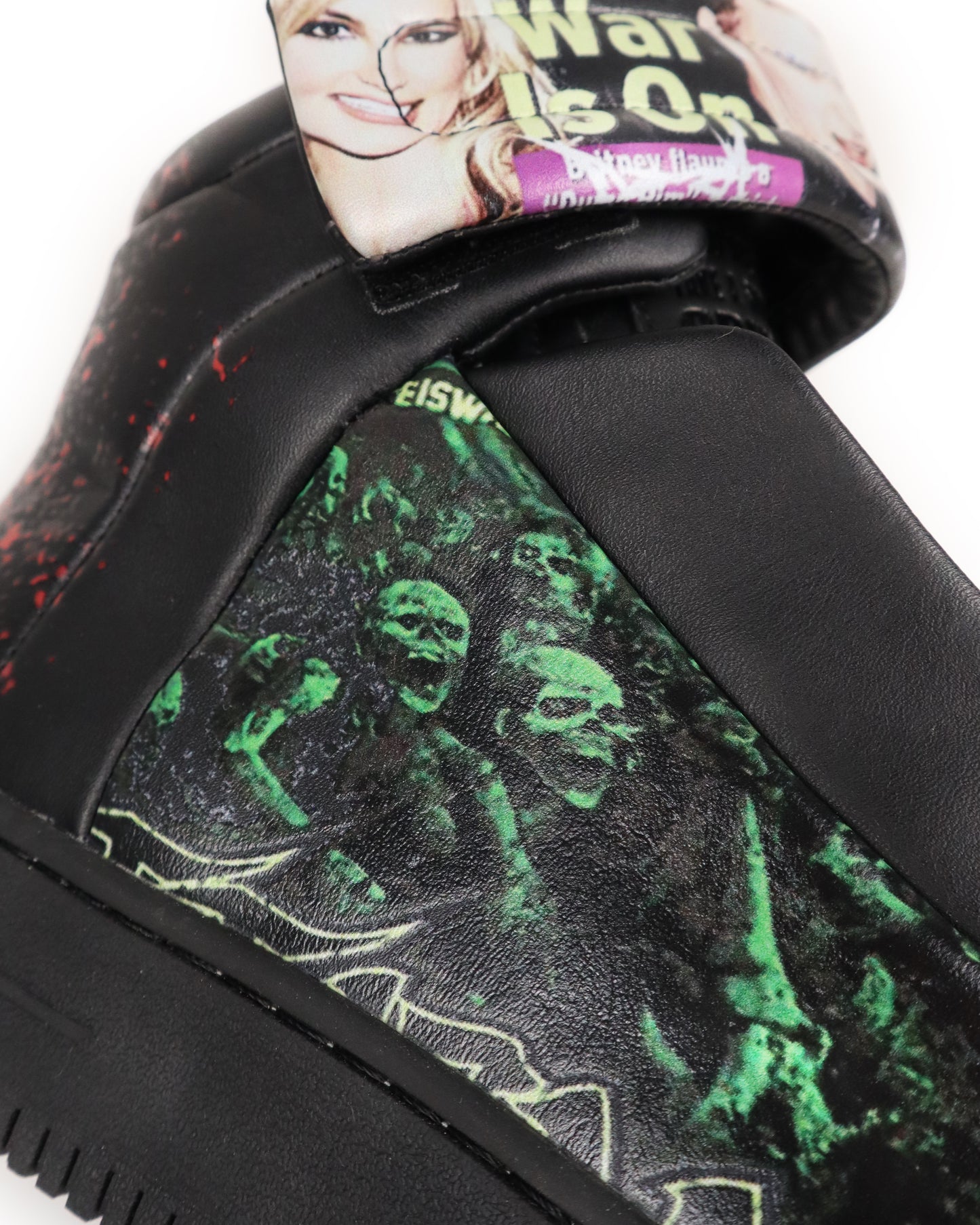 Close-up of a black sneaker with green skeleton design on a white background