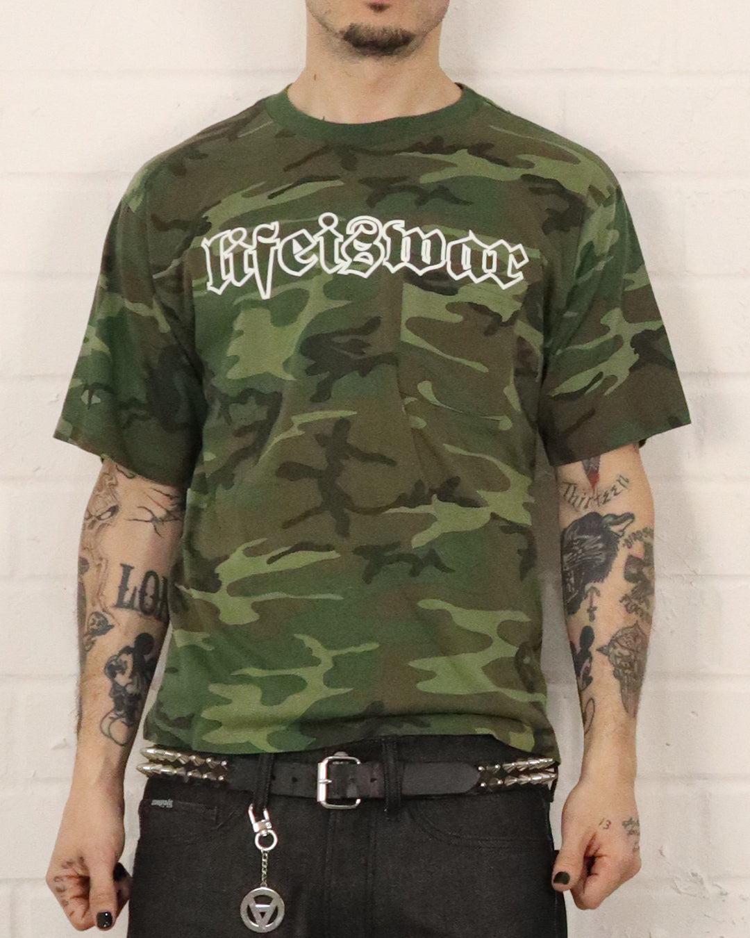 Person wearing a camouflage t-shirt with 'Life is War' text on a white background