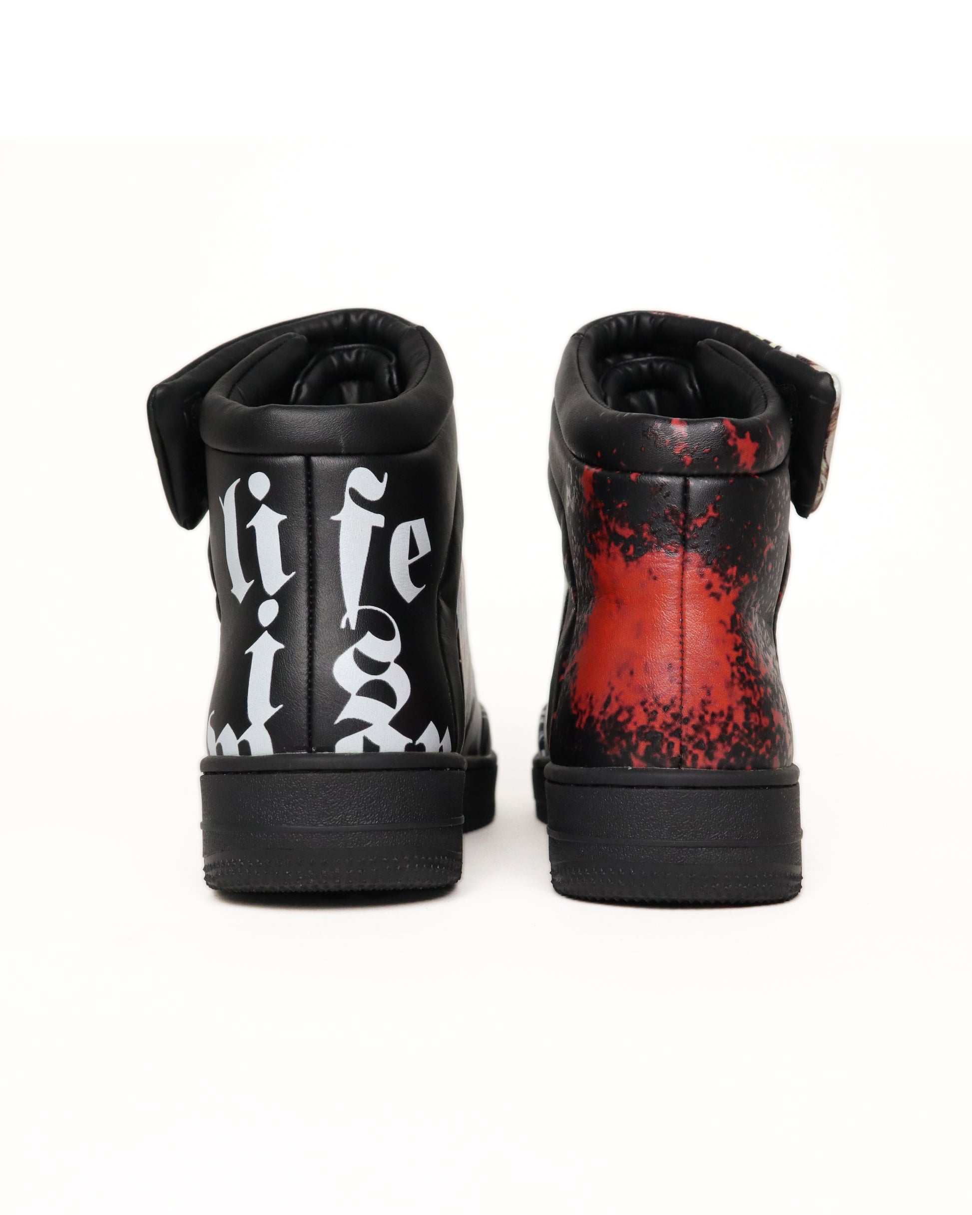Black high-top sneakers with white text and red splatter design on a white background